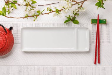 Kiraz çiçeği dalı ve yemek çubuklarıyla süslenmiş masa, Japon yemek kültürünün somut örneği, geniş bir kopya alanı sağlıyor.