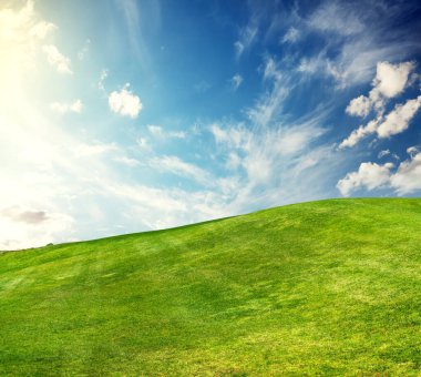 Güneşli bir manzara gözler önüne seriliyor, ihtişamlı gökyüzünün altında titizlikle budanmış yeşil çimenler, sükunet ve doğal güzelliği çağrıştırıyor.