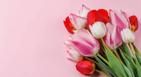 stock image Pastel colorful tulips grace the table, providing a serene and vibrant backdrop, perfect for spring celebrations or simple joys
