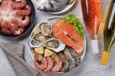 Deniz ürünleri tabağı, karides, somon, istiridye. Şarap şişeleriyle yatıyordu.