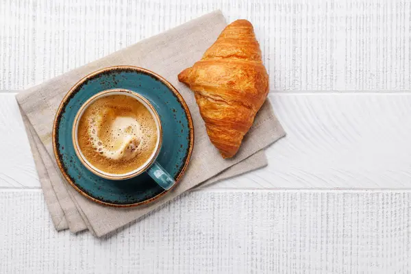 Cappuccino kahve ve ahşap masada taze kruvasan. Kopyalama alanı olan düz