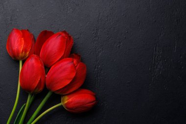 Kırmızı laleler sofrayı şereflendirir, dingin ve canlı bir zemin sağlar, bahar kutlamaları ya da basit mutluluklar için mükemmeldir.