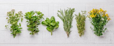 Masanın üzerinde çeşitli otlar ve baharatlar var. Mutfağa canlı renkler ve zengin aromalar ekliyorlar.