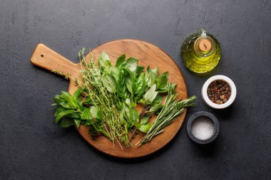 Masanın üzerinde çeşitli otlar ve baharatlar var. Mutfağa canlı renkler ve zengin aromalar ekliyorlar.