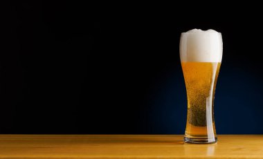 Bardaki bira: Ahşap bir masada bira fıçısını tazeliyor. Kopyalama alanı ile