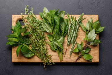 Masanın üzerinde çeşitli otlar ve baharatlar var. Mutfağa canlı renkler ve zengin aromalar ekliyorlar.