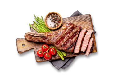 Orta pişmiş Tomahawk bifteği ve kuşkonmaz. Düz yatıyordu. Beyaz arkaplanda izole