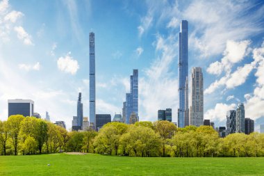 Manhattan gökdelenleri ve Central Park yeşil çayırları görkemli güneşli gökyüzü