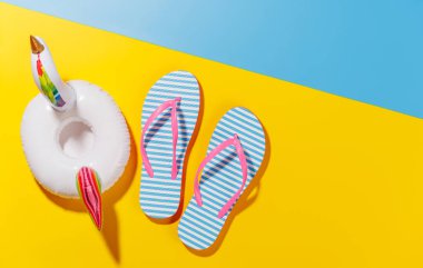 Canlı bir yaz tatili sahnesi parmak arası terlikler ve parlak bir arka planda süzülen flamingo, neşeli ve tropikal bir hava uyandırıyor.