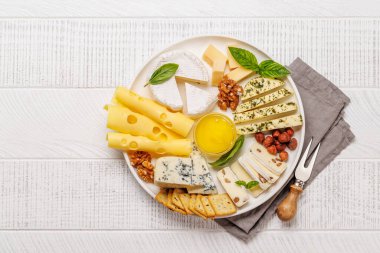 Farklı dokuları, renkleri ve tipleri vurgulayan çeşitli peynirlerden oluşan bir tabak. Tatmak ya da aperatif olarak mükemmel.