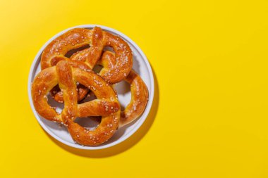 Simitler parlak sarı bir zemine saçılmış. Çubuk krakerler altın kahverengidir, mükemmel pişmiştir ve kaba tuz serpiştirilmiştir.