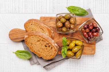 Farklı renkler, dokular ve tatlar içeren çeşitli zeytinlerden oluşan bir kâse. Düz yatıyordu