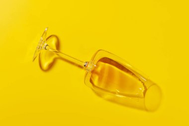 Canlı sarı bir zemin üzerinde düz duran beyaz bir şarap kadehi, minimalist düz bir şekilde çekilmiş.