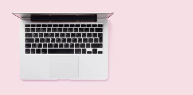 Düz yatay dizayn tarzında pembe bir arkaplana yerleştirilmiş bir dizüstü bilgisayar, içeriğiniz veya tasarımınız için yeterli kopya alanı sunar