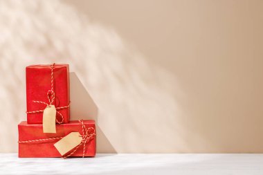 Noel şablonu, gölgeli bir masanın üzerinde hediye kutuları ve duvarın üzerine hafifçe düşen güneş ışığı ile şenlikli bir kış atmosferi yaratıyor.