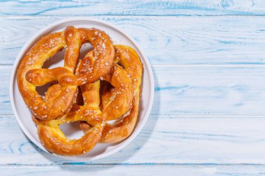 Pretzels parlak mavi bir zemin boyunca dağılmış. Çubuk krakerler altın kahverengidir, mükemmel pişmiştir ve kaba tuz serpiştirilmiştir.