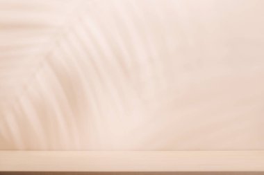 Boş masa ve duvarlı şablon doğal bitki gölgesi ve güneşli parıltı, ürün sunumu ve modelleme için mükemmel