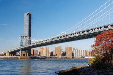 Manhattan Köprüsü 'nün arka planında Manhattan gökdelenleri olan ikonik görüntüsü, Dumbo' dan çekilmiş, ışıl ışıl bir gökyüzü altında kentsel zarafet sergiliyor.