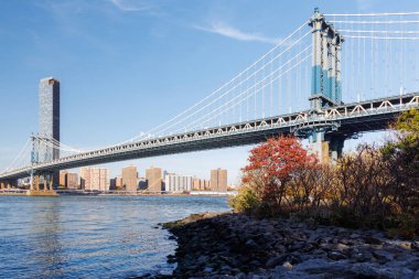 Manhattan Köprüsü 'nün arka planında Manhattan gökdelenleri olan ikonik görüntüsü, Dumbo' dan çekilmiş, ışıl ışıl bir gökyüzü altında kentsel zarafet sergiliyor.