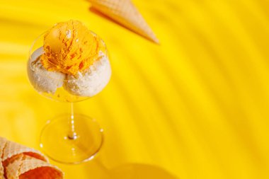 Canlı sarı bir arka plana karşı serinletici bir dondurma seti, neşeli ve yaz havası yayıyor.