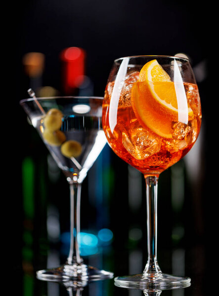 Various cocktails on a bar table. The colorful bokeh of illuminated bottles in the background enhances the mood, creating a dynamic and lively ambiance