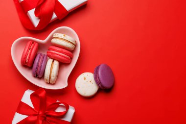 Renkli kurabiyeler kalp şeklinde bir kasede zarif bir şekilde yerleştirilmiş, büyüleyici Sevgililer Günü hediye kutularıyla eşleştirilmiş. Aşkı kutlamak için harika ve romantik bir gösteri.