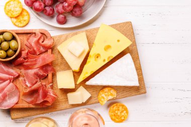 Çeşitli peynirler, taze üzümler, prosciutto ve şaraptan oluşan nefis bir düzenleme gurme yemek deneyimi için zarif bir gösteri yaratıyor. Şarap ve peynir aşıkları için mükemmel.