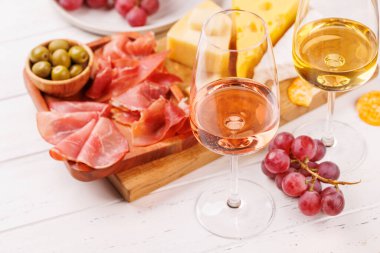 Çeşitli peynirler, taze üzümler, prosciutto ve şaraptan oluşan nefis bir düzenleme gurme yemek deneyimi için zarif bir gösteri yaratıyor. Şarap ve peynir aşıkları için mükemmel.