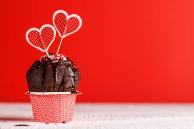 Cupcake love: Heart-themed treats on a vibrant red backdrop with copy space for your Valentines day greetings clipart