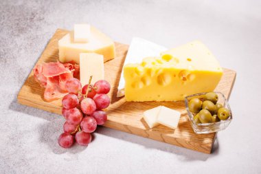 Çeşitli peynirler, taze üzümler, prosciutto ve zeytinlerden oluşan nefis bir düzenleme gurme yemek deneyimi için zarif bir gösteri yaratıyor. Şarap ve peynir aşıkları için mükemmel.