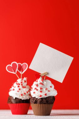 Cupcake love: Heart-themed treats on a vibrant red backdrop with copy space for your Valentines day greetings clipart