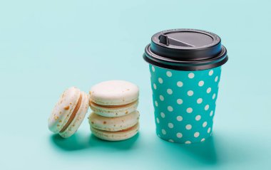 Makaronların pastel mavi arka planda kağıt kahve fincanıyla eşleştirilmesi. Kahve molası, tatlı ya da kutlama teması için mükemmel.