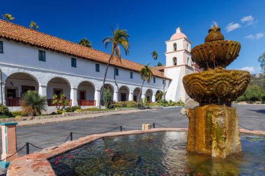 The historic Santa Barbara Mission, known as the Queen of the Missions stands majestically with its Spanish colonial architecture, twin bell towers, and beautiful rose garden clipart