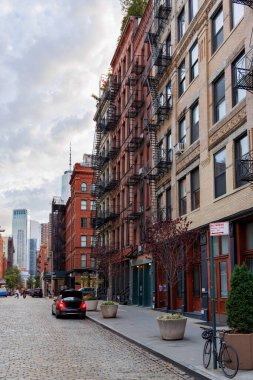 Manhattan 'ın ikonik gökdelenleri tarafından çerçevelenmiş New York şehrinin dinamik kentsel enerjisini ve mimari ihtişamını gözler önüne seren hareketli New York şehir merkezi caddesinin büyüleyici manzarası.