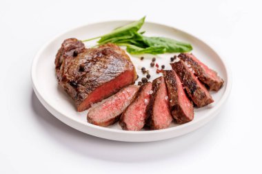 Beyaz arka planda sulu, yumuşak bir dokusu olan mükemmel pişirilmiş çizgili biftek. Biftek ve şarap aşıkları için gurme yemeği