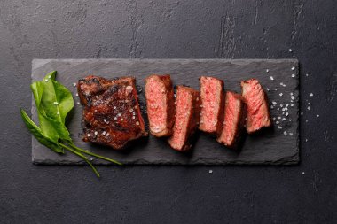 Mükemmel pişirilmiş çizgili biftek ve sulu, yumuşak bir arka plan. Biftek ve şarap aşıkları için gurme yemeği