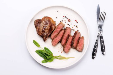 Beyaz arka planda sulu, yumuşak bir dokusu olan mükemmel pişirilmiş çizgili biftek. Biftek ve şarap aşıkları için gurme yemeği