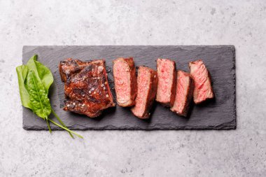 Mükemmel pişirilmiş çizgili biftek ve sulu, yumuşak bir arka plan. Biftek ve şarap aşıkları için gurme yemeği