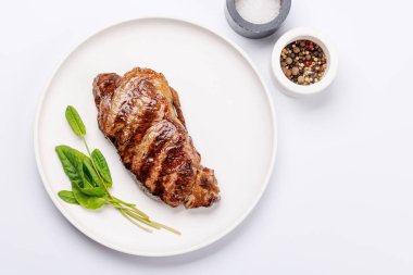 Beyaz arka planda sulu, yumuşak bir dokusu olan mükemmel pişmiş çizgili biftek. Biftek ve şarap aşıkları için gurme yemeği