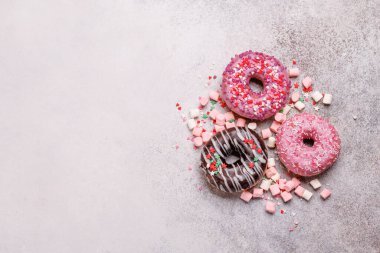 Taş bir arka planda renkli badem kurabiyelerinin göz alıcı bir düzeni. Gösterişli tatlılar ya da eğlenceli ve hareketli estetik tatlılar için mükemmel.