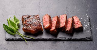 Mükemmel pişirilmiş çizgili biftek ve sulu, yumuşak bir arka plan. Biftek ve şarap aşıkları için gurme yemeği