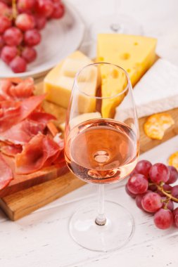 Çeşitli peynirler, taze üzümler, prosciutto ve şaraptan oluşan nefis bir düzenleme gurme yemek deneyimi için zarif bir gösteri yaratıyor. Şarap ve peynir aşıkları için mükemmel.