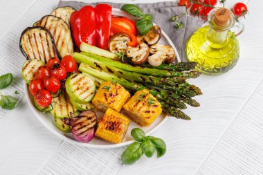 Tabakta çeşitli ızgara sebzeler, renkli ve sağlıklı bir yemek sergileniyor.