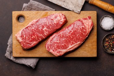 Çiğ mermer çizgili biftek, taze, zengin, pişirmeye hazır. Düz yatıyordu