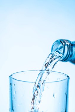 Şeffaf bardağa buzla doldurulan kristal berrak su canlandırıcı kabarcıklar ve kabarcıklar yaratır. Su ve saflığın mükemmel bir temsili.