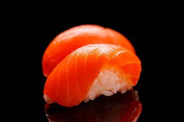 Somon balığı güzel düzenlenmiş, taze malzemeler ve canlı renkler içeren, temiz siyah bir arka planda.