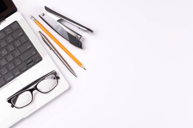 Dizüstü bilgisayar ve ofis malzemelerinin yer aldığı, tasarım veya metin için geniş bir kopya alanı olan verimli bir çalışma alanı yaratan bir masa