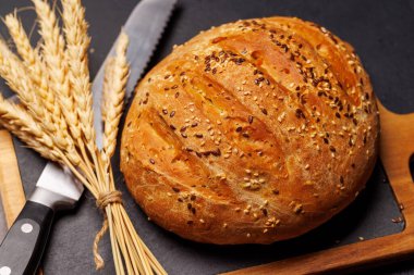 Bir somun taze ev yapımı ekmek. Altın kabuklu, yumuşak, havadar bir dokuya sahip. Sıcak ve davetkar bir koku yayıyor.