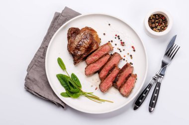 Beyaz arka planda sulu, yumuşak bir dokusu olan mükemmel pişirilmiş çizgili biftek. Biftek ve şarap aşıkları için gurme yemeği