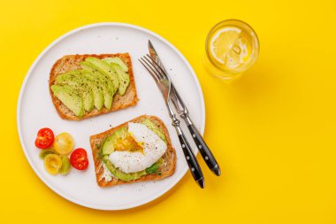 Lezzetli avokado tostları mükemmel pişirilmiş haşlanmış yumurtalarla, sağlıklı ve besleyici bir yemek için çıtır ekmekle servis edilir.
